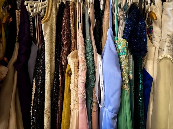 A rail of occasion dresses and gowns in sequins, lace and satin inside the boutique