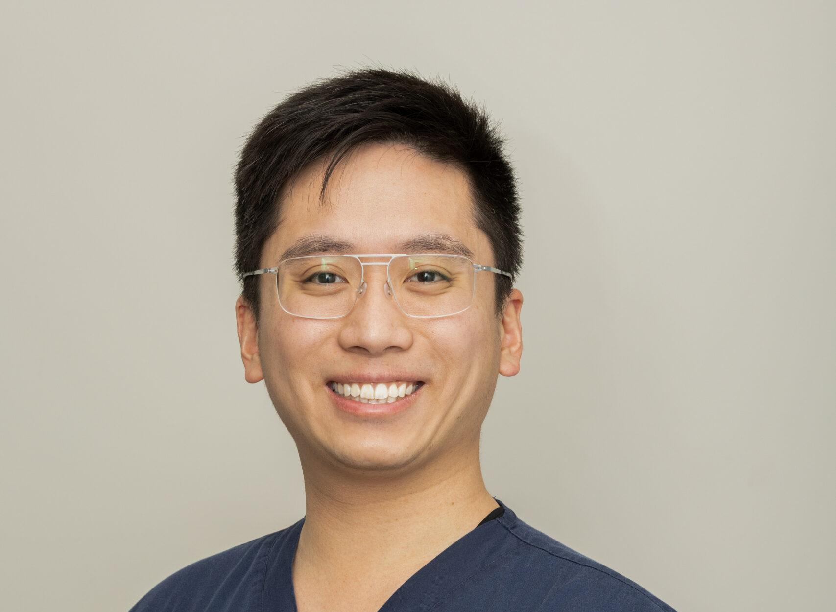 Portrait of the clinic's lead dentist in scrubs