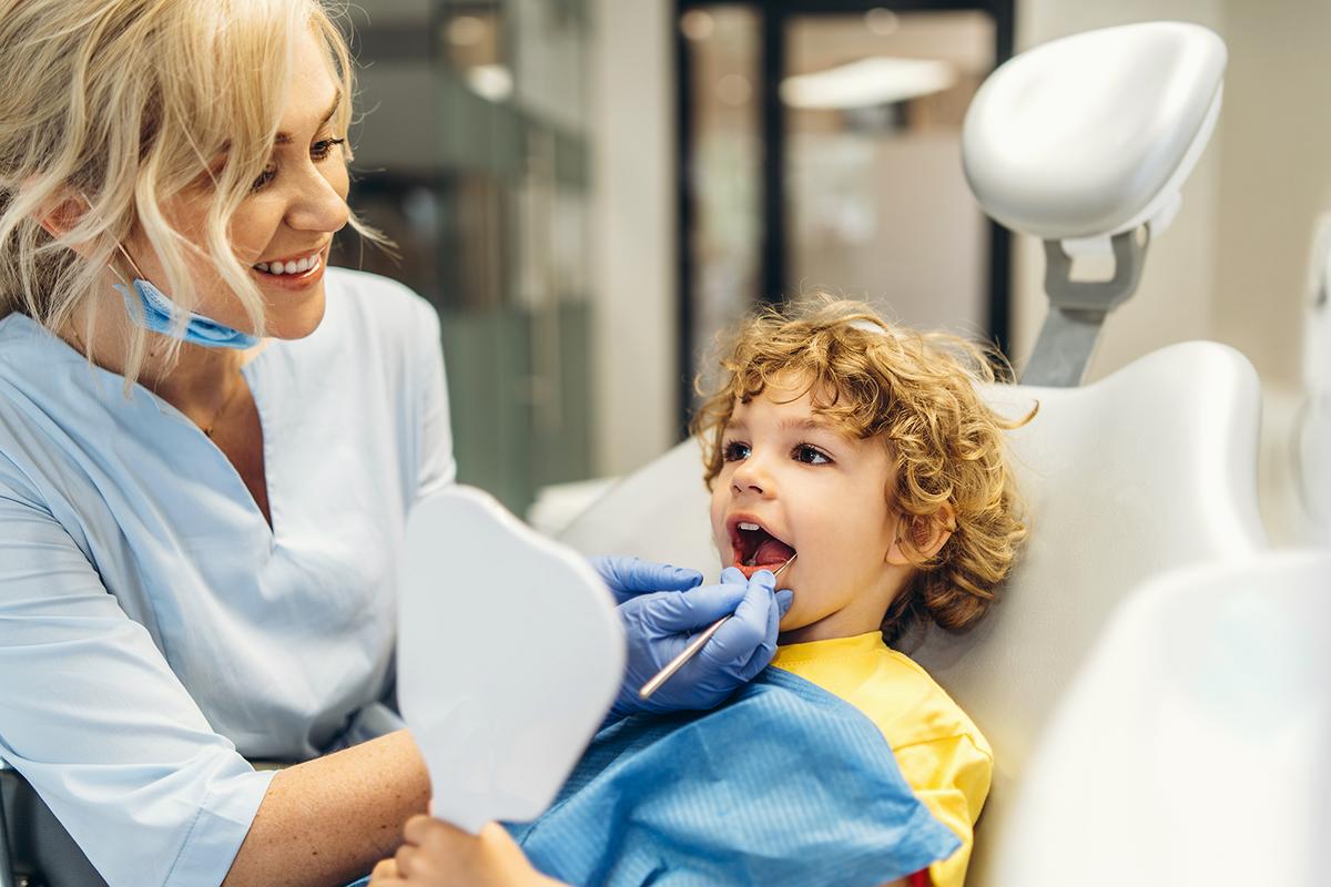 A young patient smiling through a gentle dental checkup