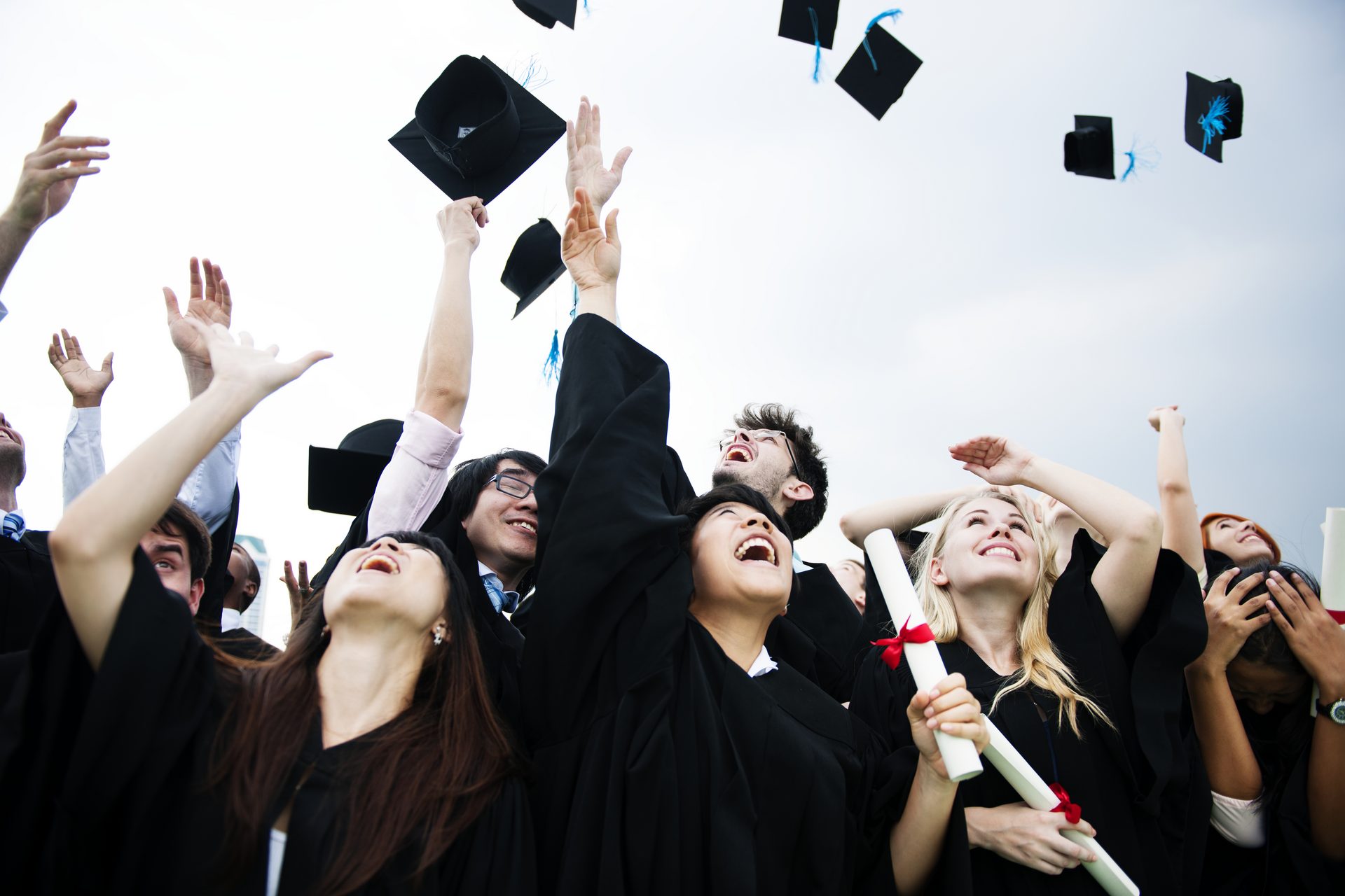 Graduates celebrating by throwing their caps into the air