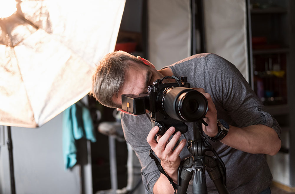Photographer taking a portrait in the studio with a large softbox light