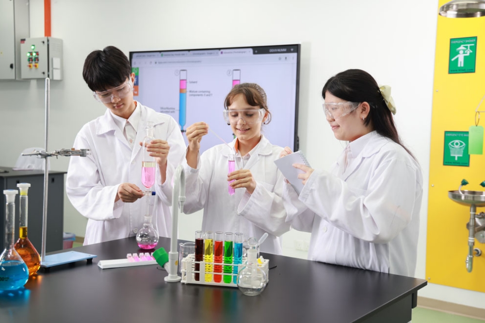 Students in white coats running an experiment in the science laboratory