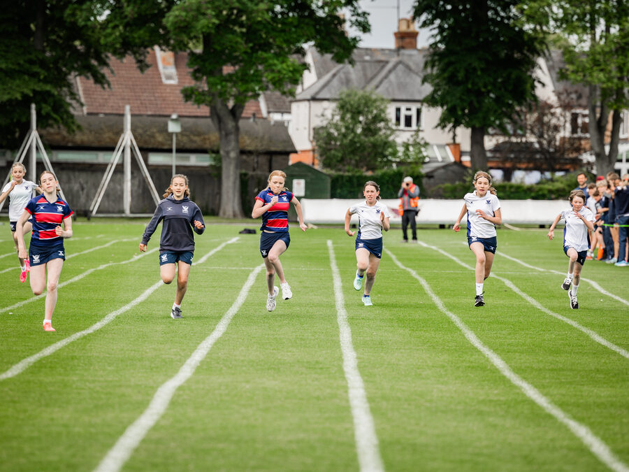 Students sprinting on the school sports field during athletics practice